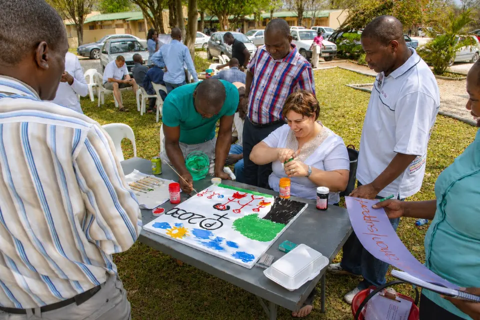 Participants painting together at an outdoor table