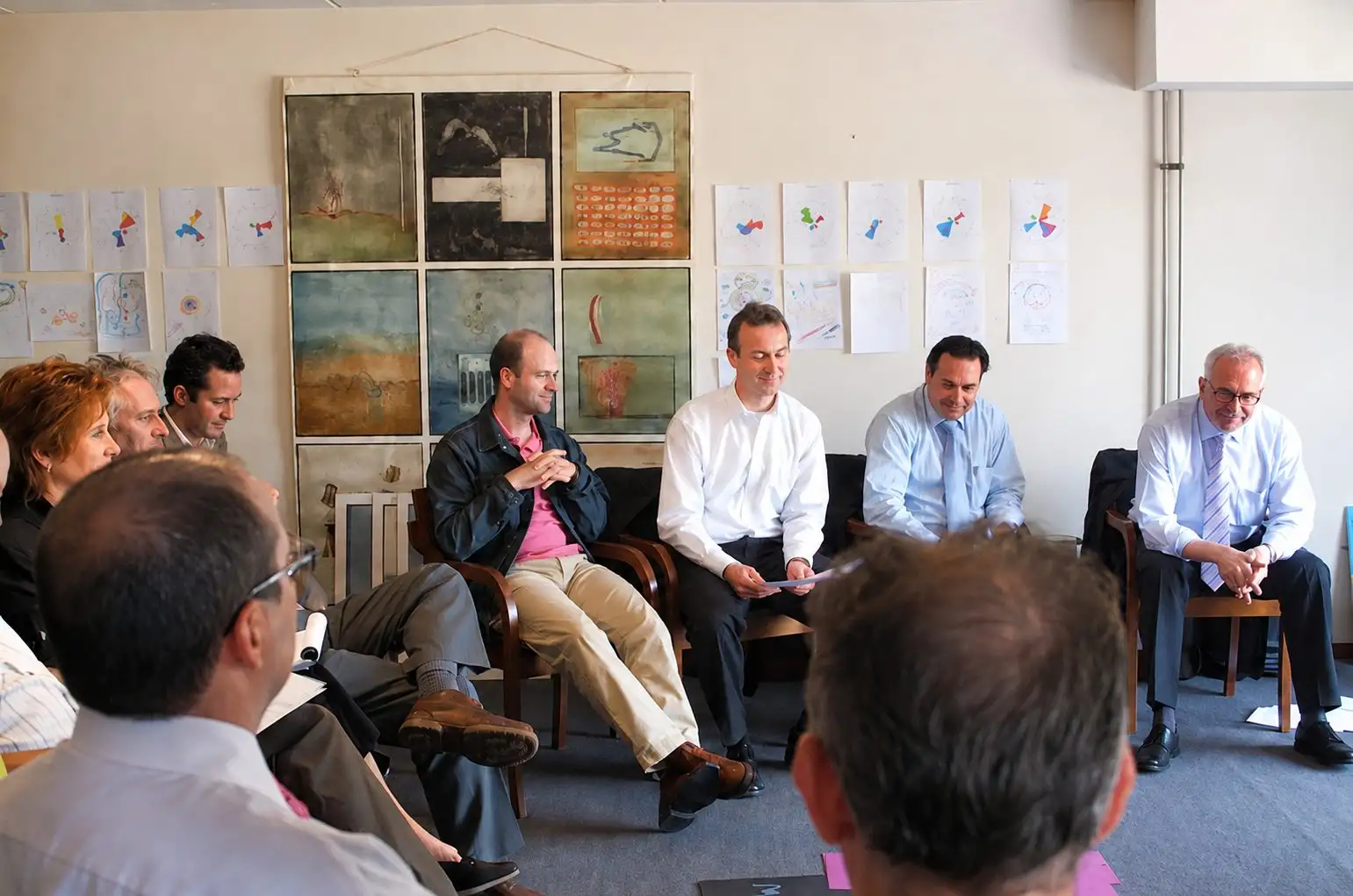 Leadership team seated in a circle of chairs, listening to each other