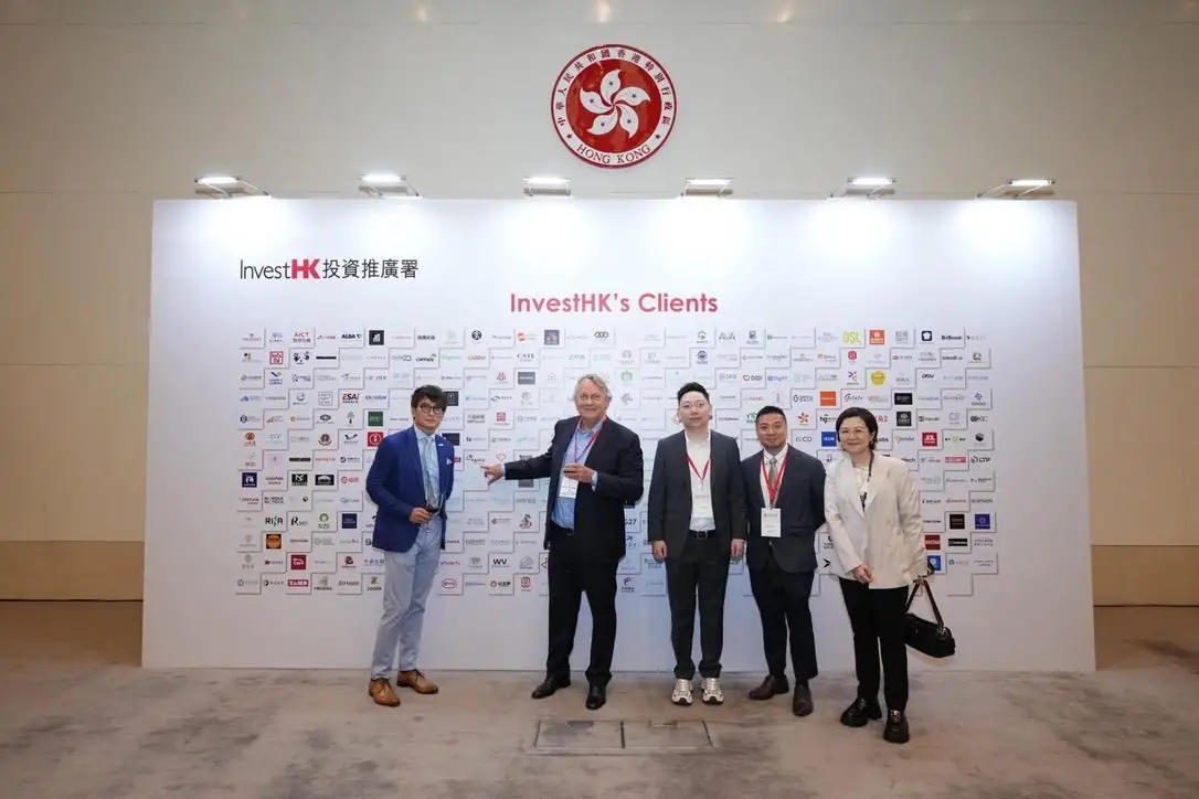 Five guests in front of the InvestHK’s Clients logo wall