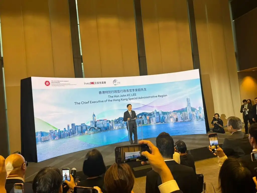 Speaker on stage at the welcome reception, with guests taking photos
