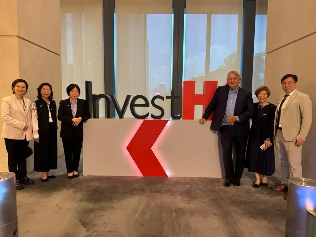 Guests posing beside the InvestHK sign at the reception
