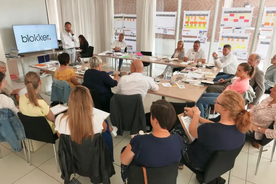 Blokker employees seated at long tables during the dialogue