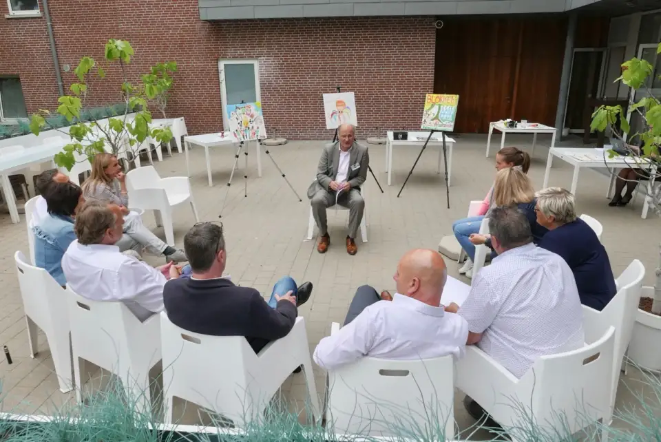 Small group in a circle of white chairs in a courtyard