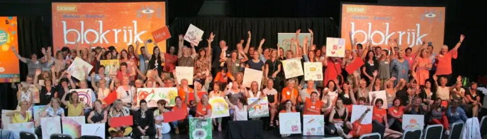 Large group of Blokker employees cheering in front of a Blokker banner