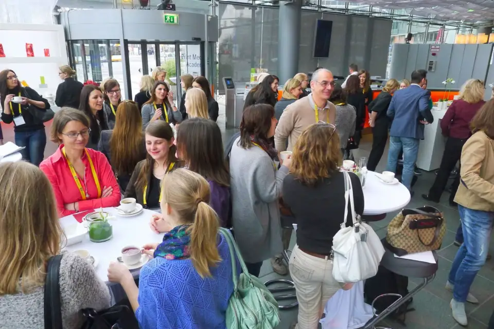 EY participants talking around high tables in an atrium