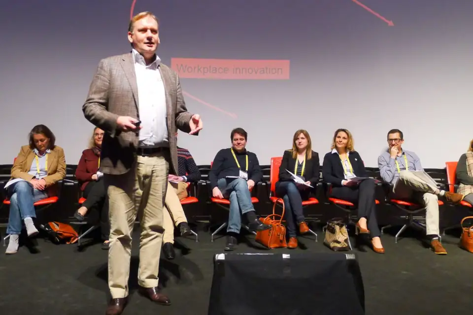 Speaker standing in front of a row of seated panellists