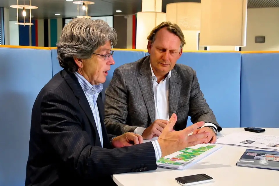 Two executives discussing papers at a table