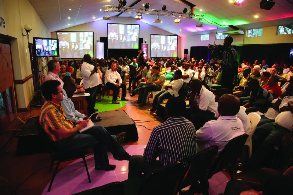 Large audience seated in a hall facing the stage