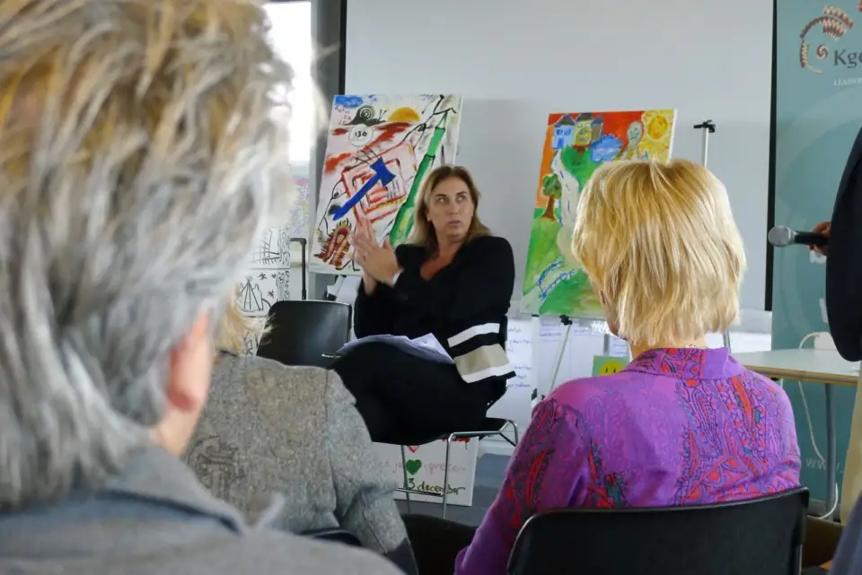 Participants in conversation in front of colourful artworks