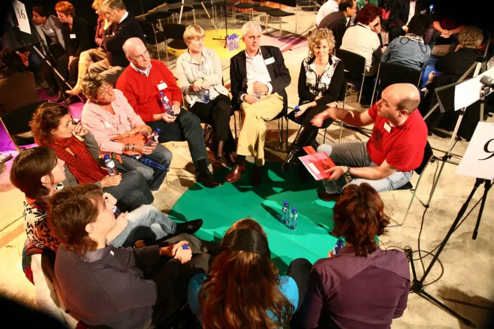 Participants in conversation in a circle of chairs