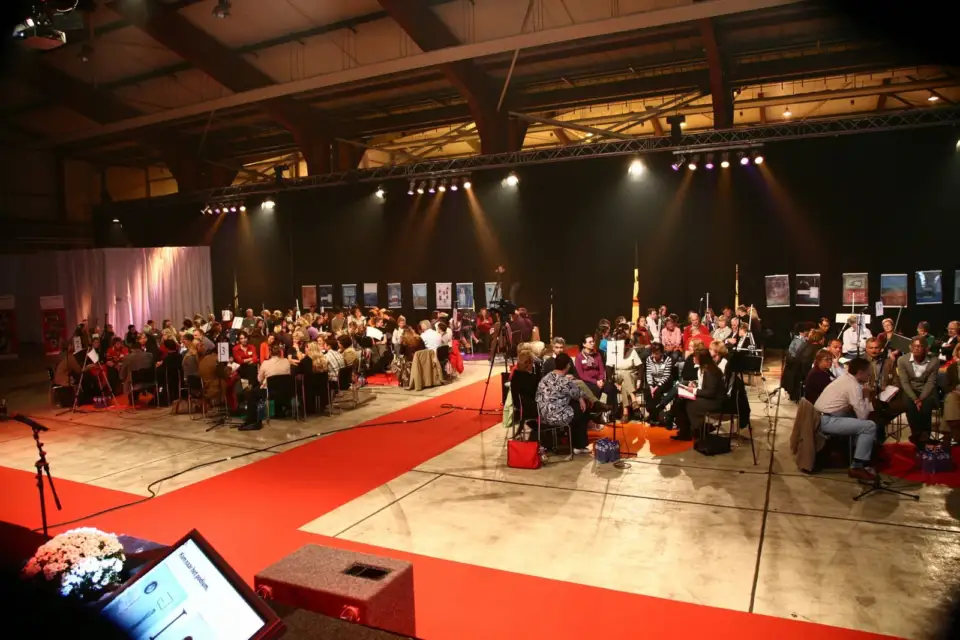 Hall full of small dialogue groups, with a red carpet in the foreground