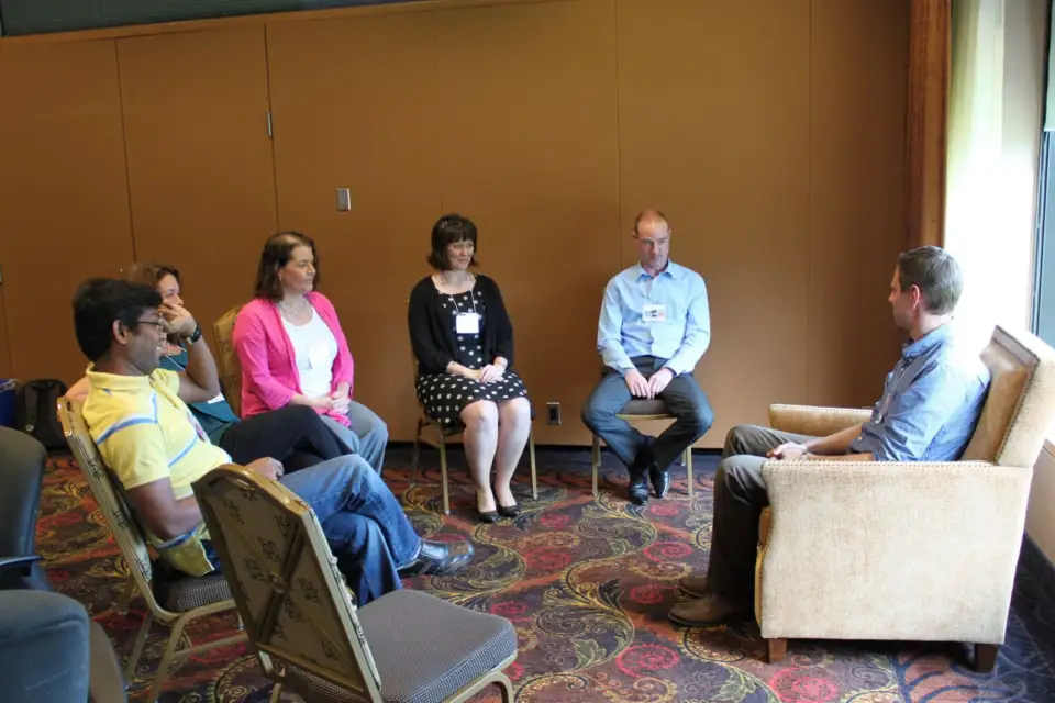 Small group of Tennant colleagues in conversation in armchairs