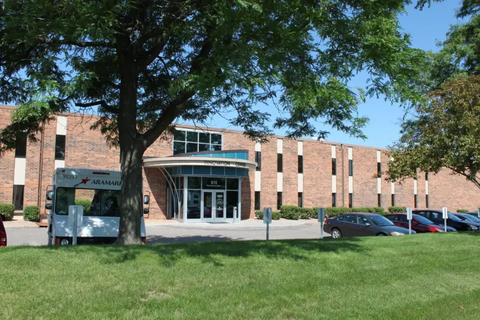 Tennant office building behind trees and a lawn