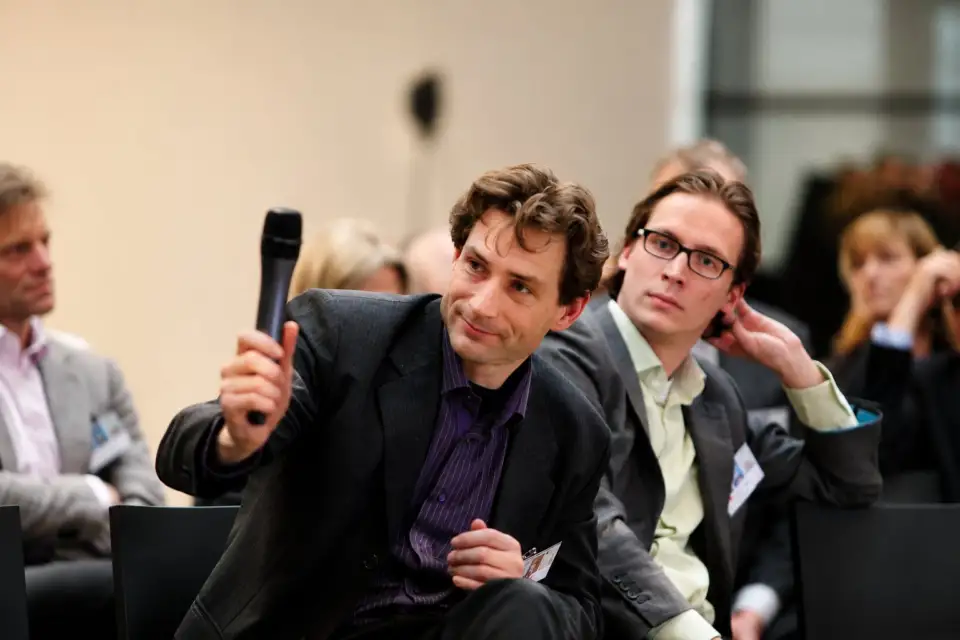 Participant speaking into a microphone during a leadership dialogue
