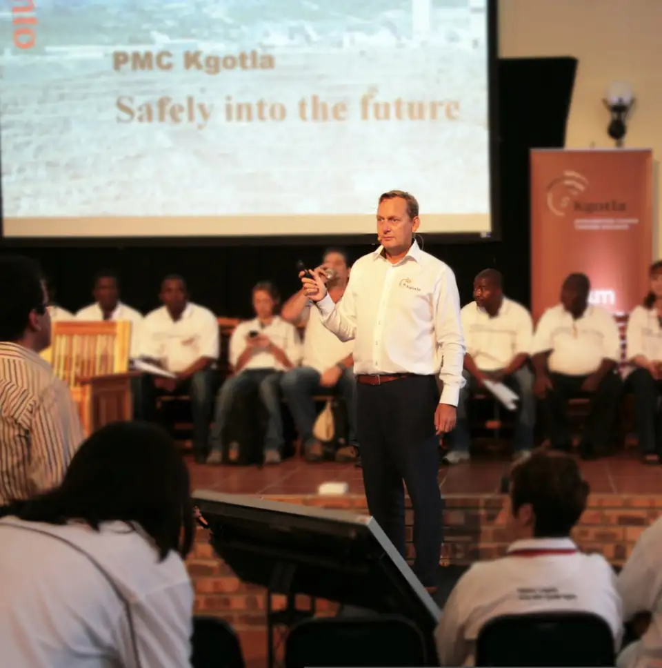 Facilitator speaking on a stage to an audience